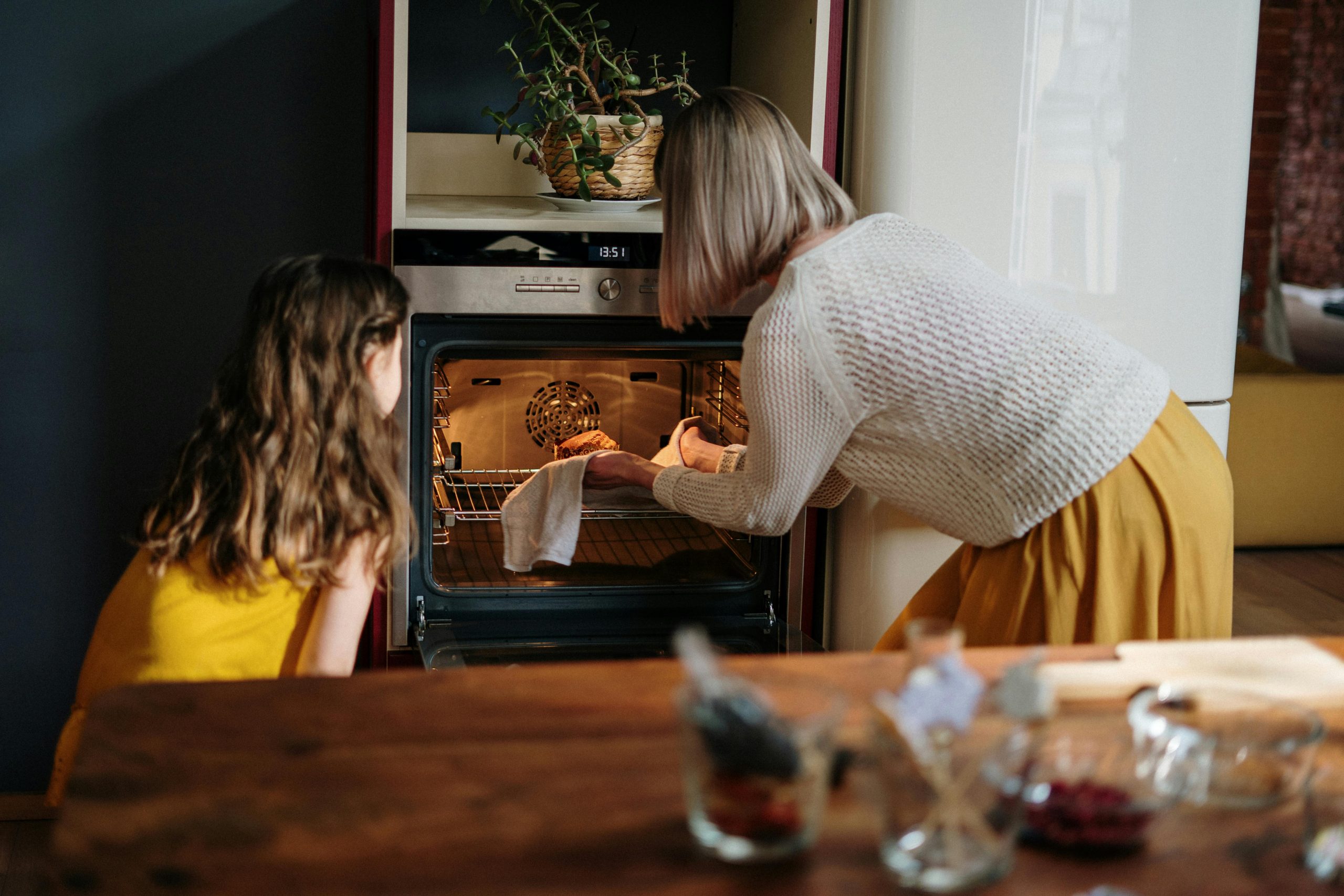 Une maman et sa famille sortant un plat du four