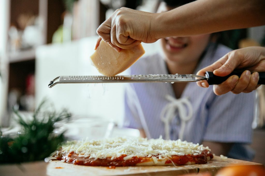 Une main qui râpe du fromage