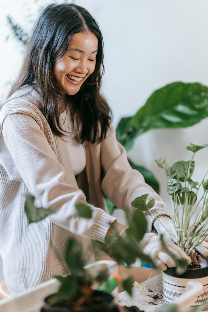 Une femme mettant une plante dans un pot